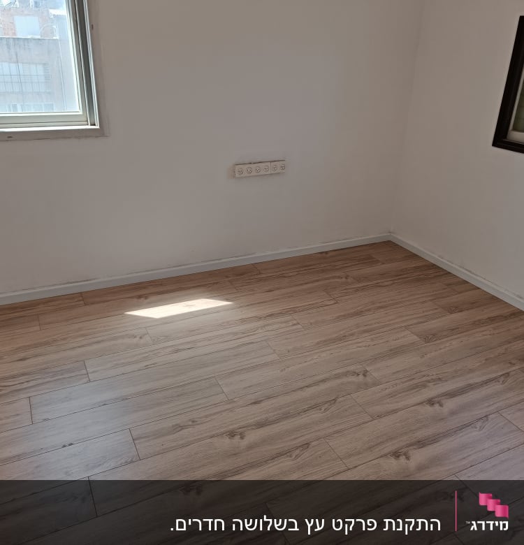 רצפת פרקט עץ בהירה בחדר ריק עם חלונות